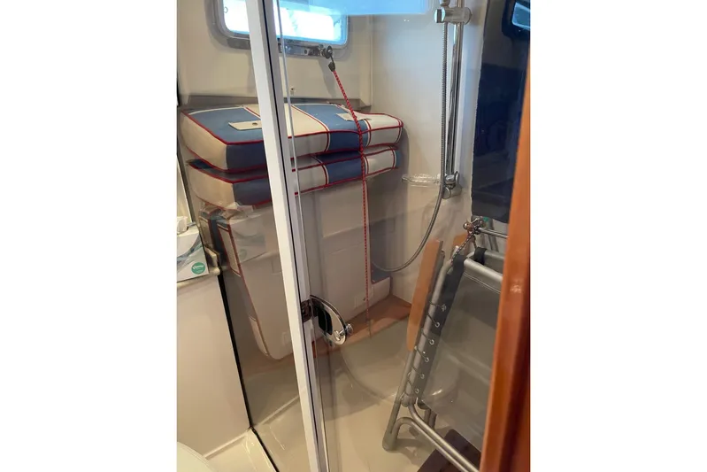 Off Islander Yacht Photos Pics Interior of 2007 Legacy Yachts 32, featuring a compact shower area with nautical cushions.