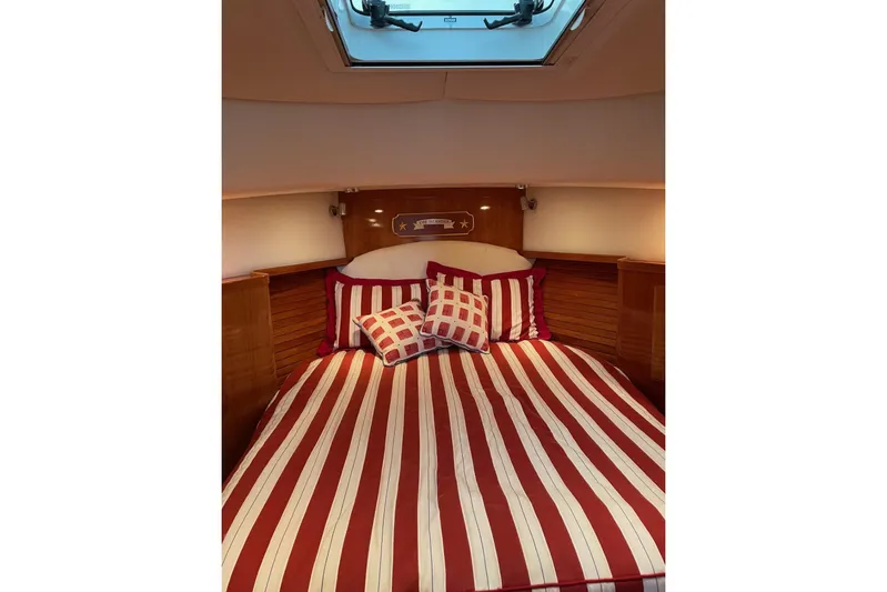 Off Islander Yacht Photos Pics Cozy cabin interior of 2007 Legacy Yachts 32 with striped bedding and skylight.
