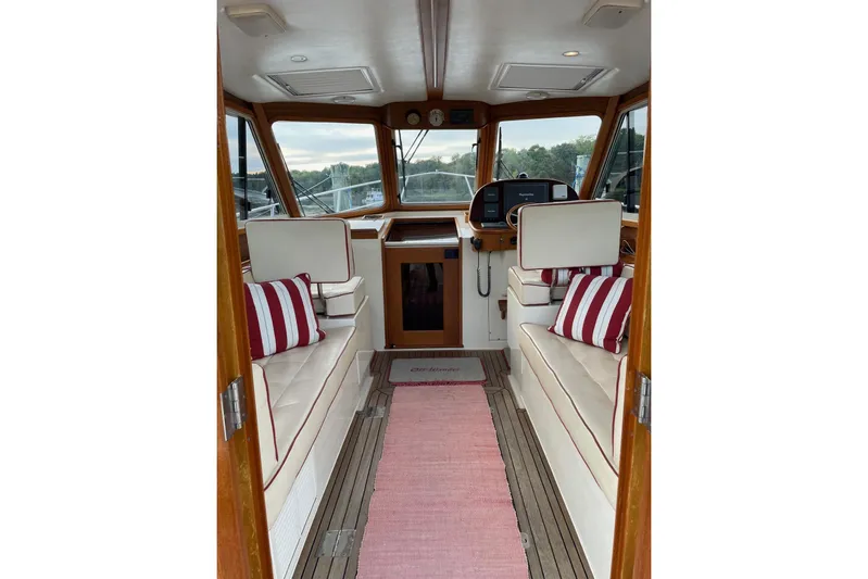 Off Islander Yacht Photos Pics Interior of 2007 Legacy Yachts 32 with striped cushions and wooden accents.