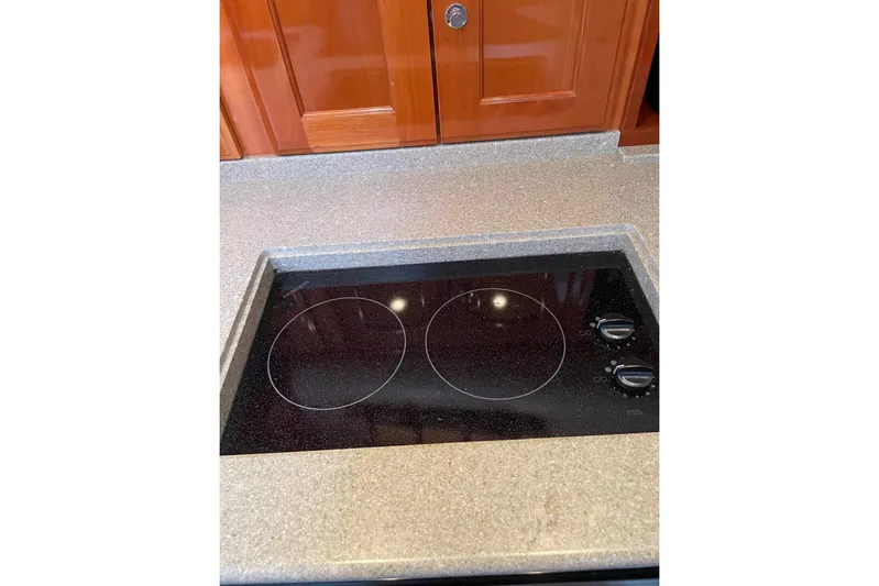 Off Islander Yacht Photos Pics Stovetop in 2007 Legacy Yachts 32 galley with wooden cabinetry.