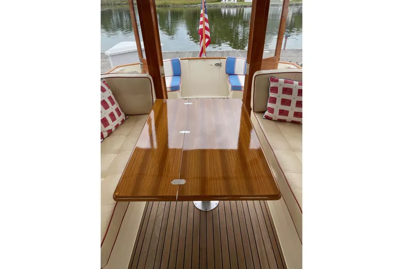 Off Islander Yacht Photos Pics Interior of 2007 Legacy Yachts 32 with polished wood table and cushioned seating.