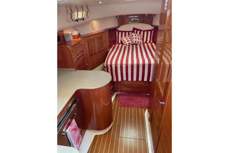 Off Islander Yacht Photos Pics Luxurious 2007 Legacy Yachts 32 interior with striped bedding and polished wood finishes.