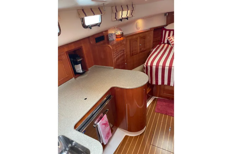 Off Islander Yacht Photos Pics Interior of 2007 Legacy Yachts 32, featuring a cozy kitchen and striped bedding.