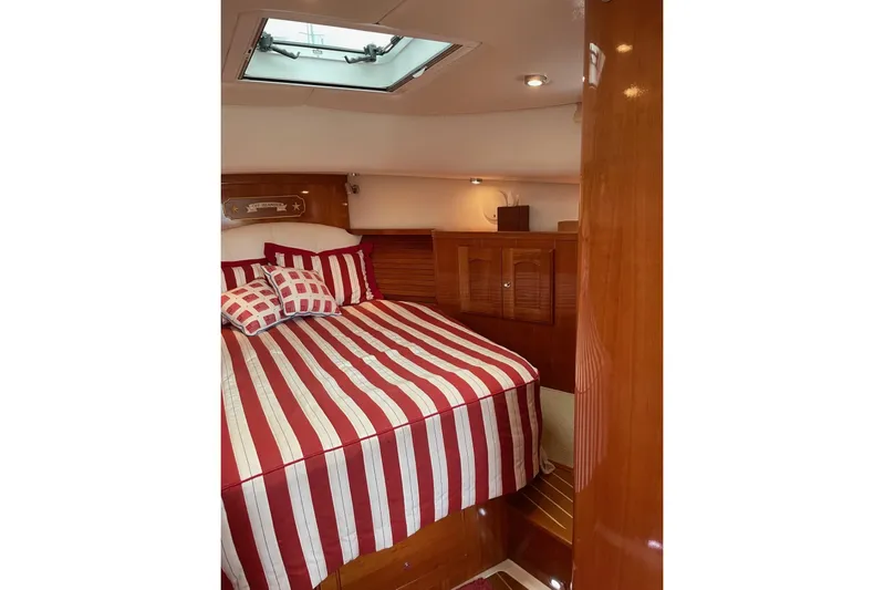 Off Islander Yacht Photos Pics Cozy cabin interior of 2007 Legacy Yachts 32 with striped bedding and wooden finishes.