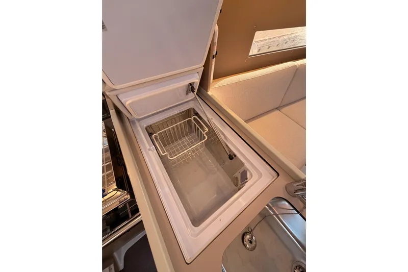  Yacht Photos Pics Interior view of 2020 Beneteau Oceanis 30.1 yacht kitchen with open refrigerator.