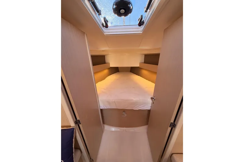  Yacht Photos Pics Cozy cabin interior of 2020 Beneteau Oceanis 30.1 sailboat with skylight and bed.