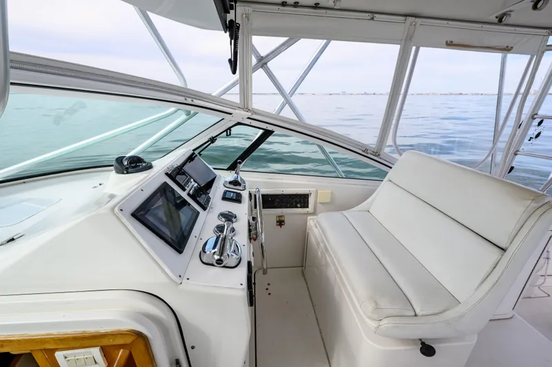 Marlin Spike Yacht Photos Pics 1998 Bertram 36 Moppie boat cockpit with modern controls and white seating, overlooking calm waters.