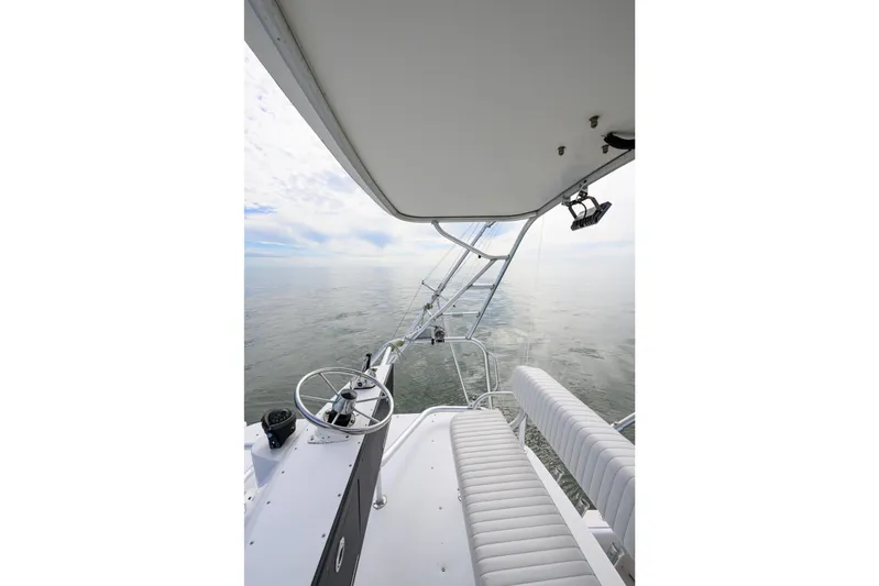 Marlin Spike Yacht Photos Pics 1998 Bertram 36 Moppie boat helm with ocean view, featuring steering wheel and seating.