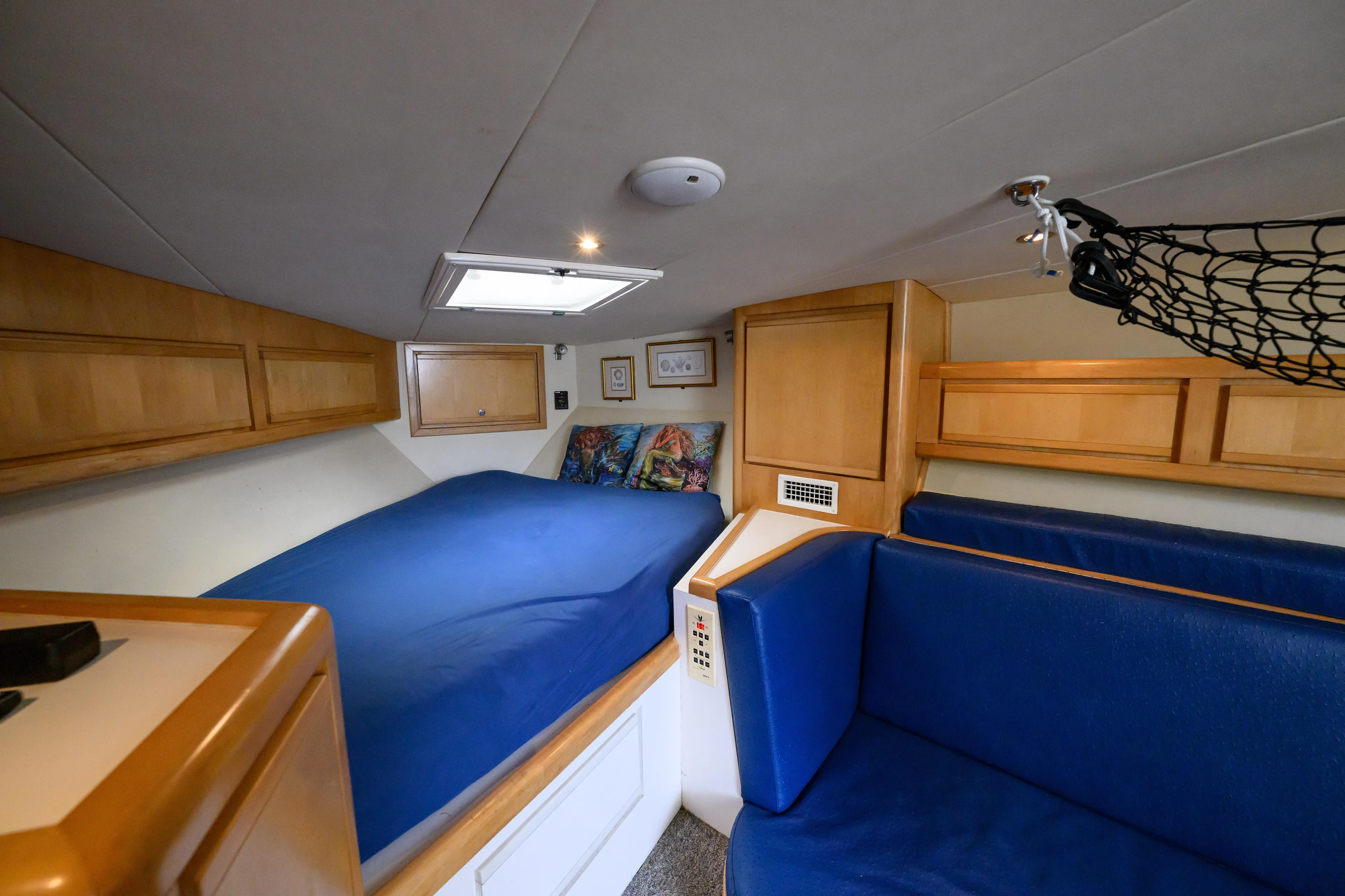 Marlin Spike Yacht Photos Pics Interior cabin of a 1998 Bertram 36 Moppie with blue bedding and wooden cabinets.