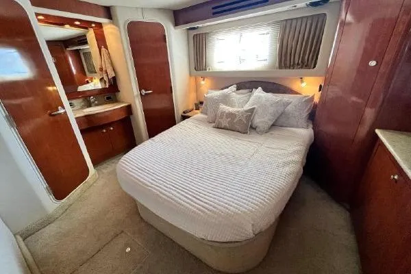 Infinity 2 Yacht Photos Pics Luxurious bedroom interior of 2004 Sea Ray 390 Motor Yacht with cozy bed and elegant decor.