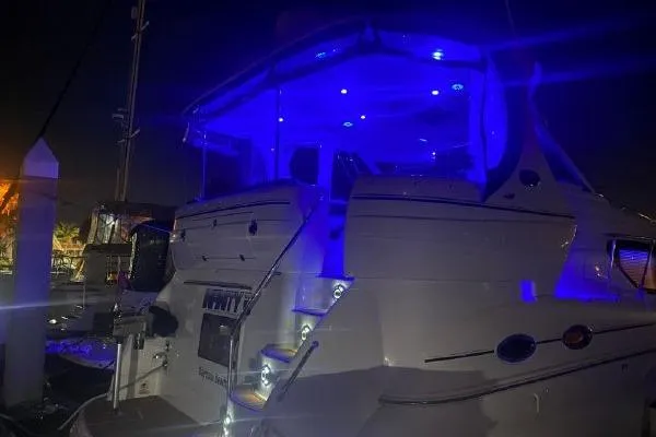 Infinity 2 Yacht Photos Pics 2004 Sea Ray 390 Motor Yacht illuminated with blue lights at night.