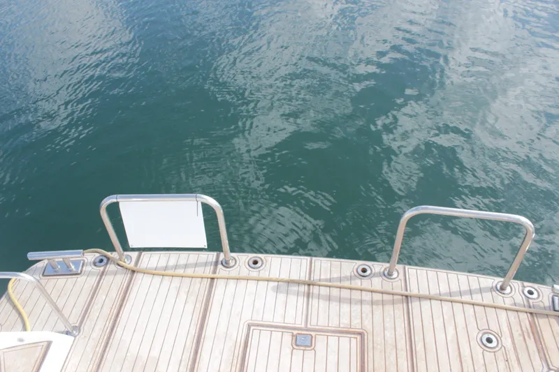 Allegro Yacht Photos Pics Stern view of 1999 Horizon 70 Motor Yacht with teak deck and water backdrop.