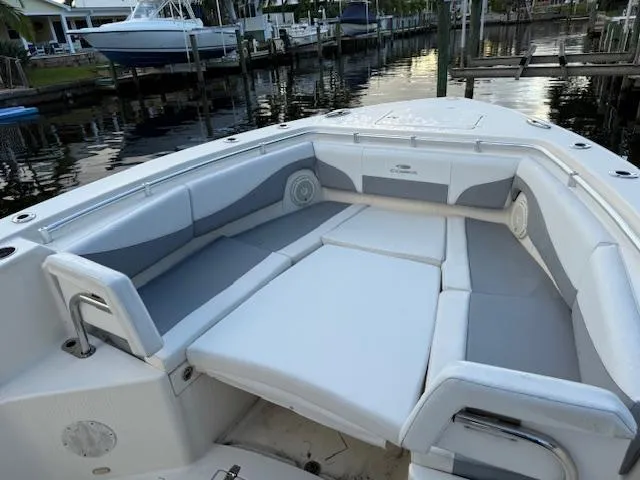  Yacht Photos Pics 2018 Cobia 320 CC boat with spacious seating area, docked by the water.