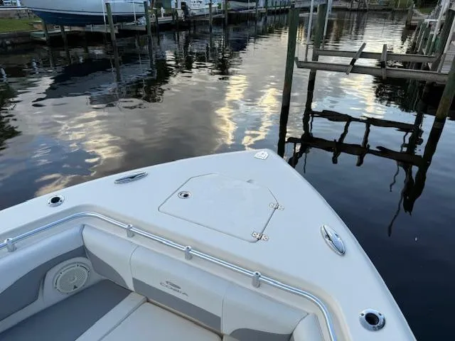  Yacht Photos Pics 2018 Cobia 320 CC boat docked on calm water, showcasing sleek design and spacious seating.