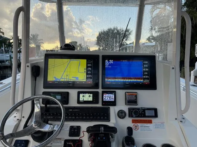  Yacht Photos Pics 2018 Cobia 320 CC boat dashboard with navigation screens and controls at sunset.