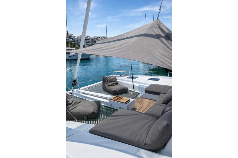  Yacht Photos Pics Luxurious Lagoon 50 catamaran deck with comfortable seating, 2022 model, docked in a serene marina.