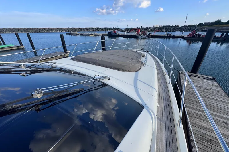  Yacht Photos Pics 2006 Azimut 68S yacht docked at marina, reflecting blue sky and clouds.