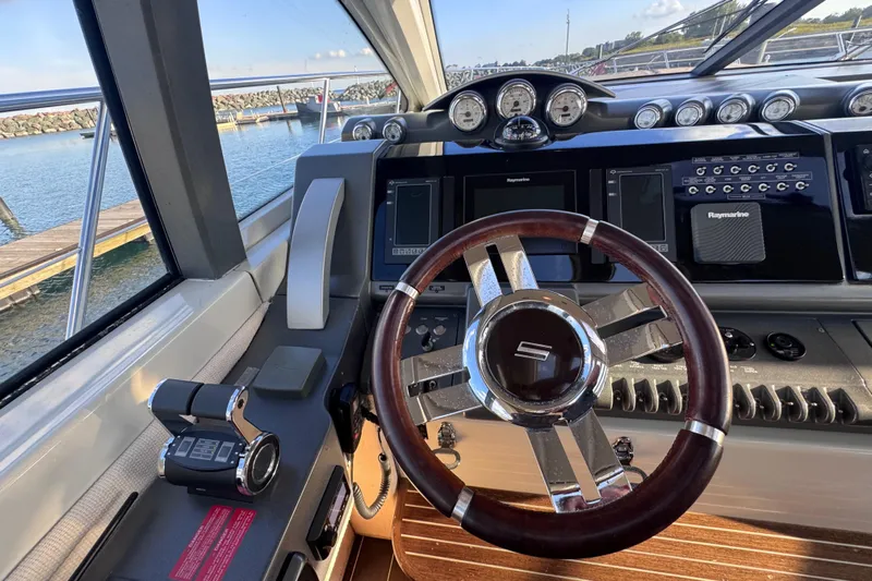  Yacht Photos Pics Steering wheel and dashboard of a 2006 Azimut 68S yacht, featuring modern navigation equipment.