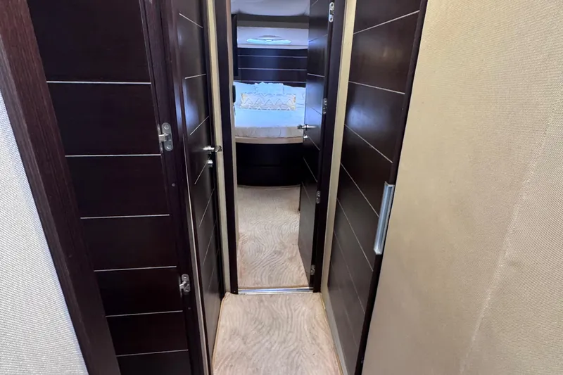  Yacht Photos Pics Interior hallway of 2006 Azimut 68S yacht, featuring dark wood doors and beige walls.