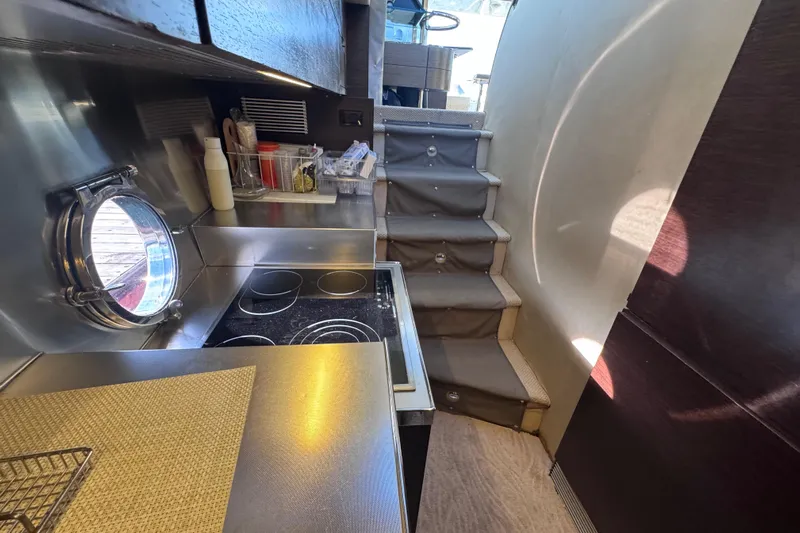  Yacht Photos Pics 2006 Azimut 68S yacht kitchen with stove, porthole, and stairs.