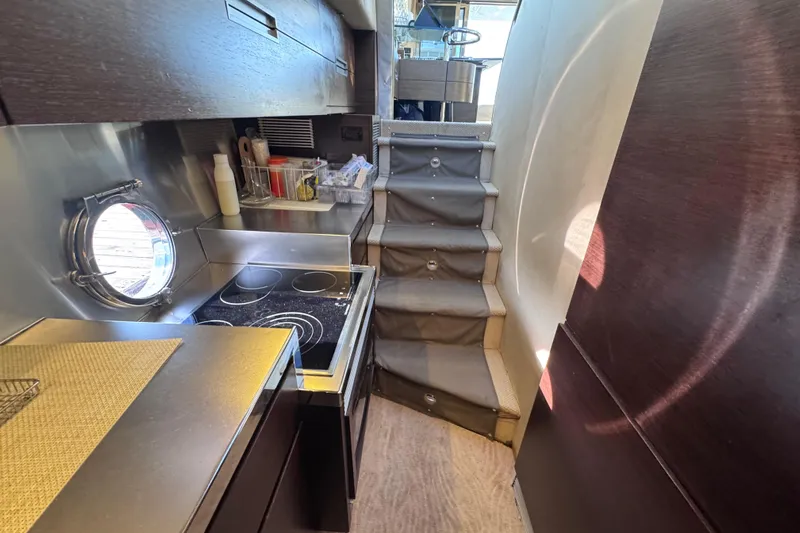  Yacht Photos Pics Compact kitchen area in 2006 Azimut 68S yacht with modern appliances and stairs.