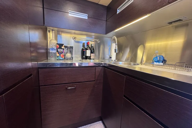  Yacht Photos Pics Luxurious kitchen area in a 2006 Azimut 68S yacht with modern fixtures and dark wood cabinetry.