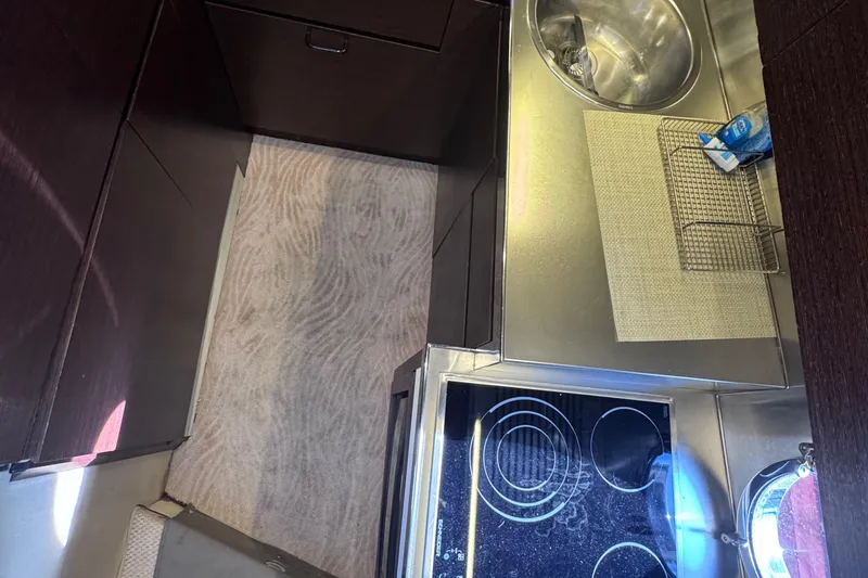  Yacht Photos Pics Compact kitchen area in a 2006 Azimut 68S yacht with stove and sink.