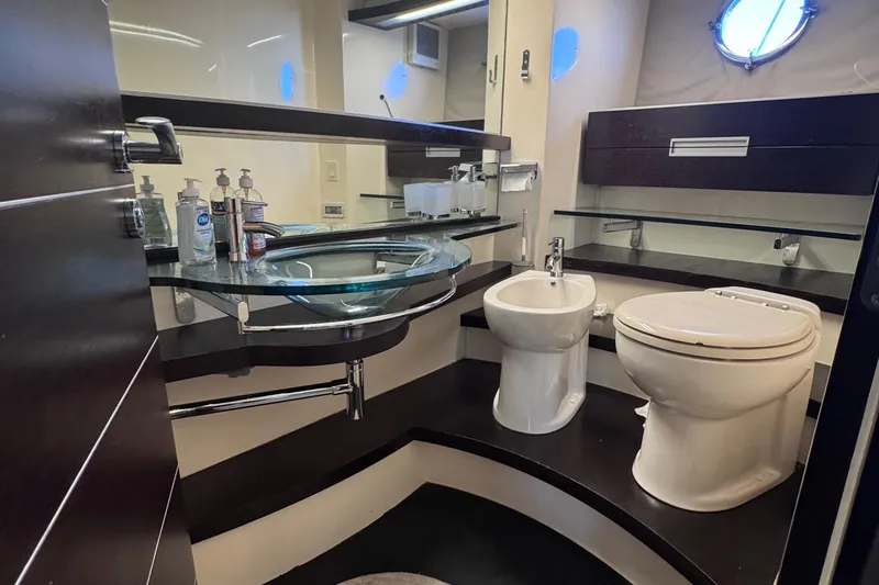  Yacht Photos Pics Luxurious bathroom in a 2006 Azimut 68S yacht with modern fixtures and glass sink.