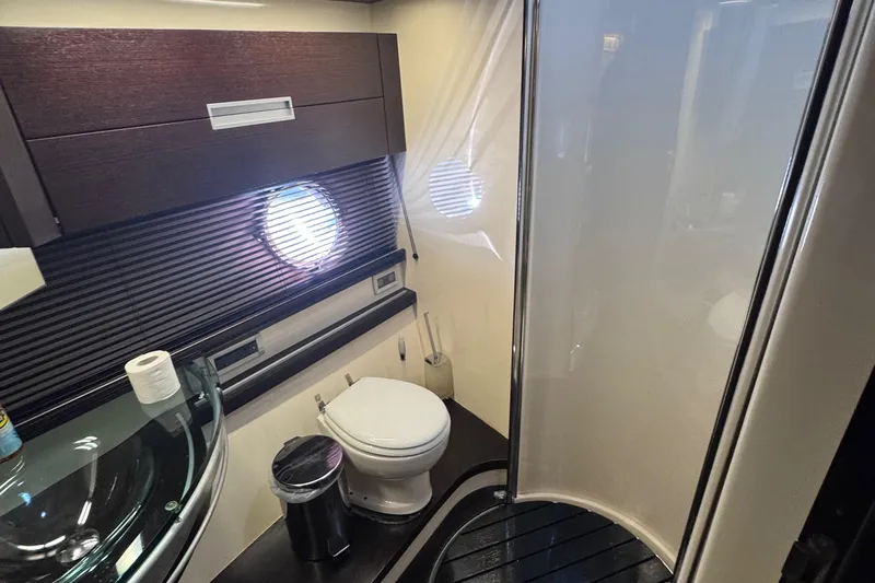 Yacht Photos Pics Luxurious bathroom in a 2006 Azimut 68S yacht with modern fixtures and porthole window.
