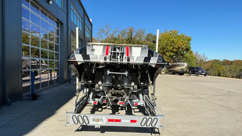  Yacht Photos Pics 2008 Fountain 47 Lightning boat on trailer, parked outside a garage on a sunny day.