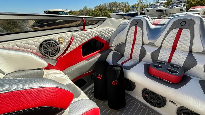 Yacht Photos Pics 2008 Fountain 47 Lightning boat interior with red and gray seating, cup holders, and speakers.