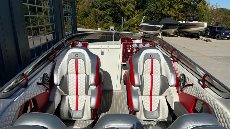  Yacht Photos Pics 2008 Fountain 47 Lightning boat interior with red and gray seating, docked near other boats.
