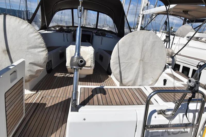 Panope Yacht Photos Pics 2009 Beneteau Oceanis 54 yacht cockpit with covered steering wheels and wooden deck.