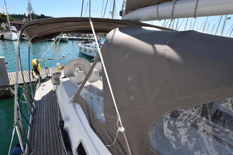 Panope Yacht Photos Pics 2009 Beneteau Oceanis 54 sailboat with canopy, docked in a marina.
