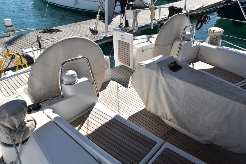 Panope Yacht Photos Pics 2009 Beneteau Oceanis 54 yacht cockpit with covered seating and steering wheels.
