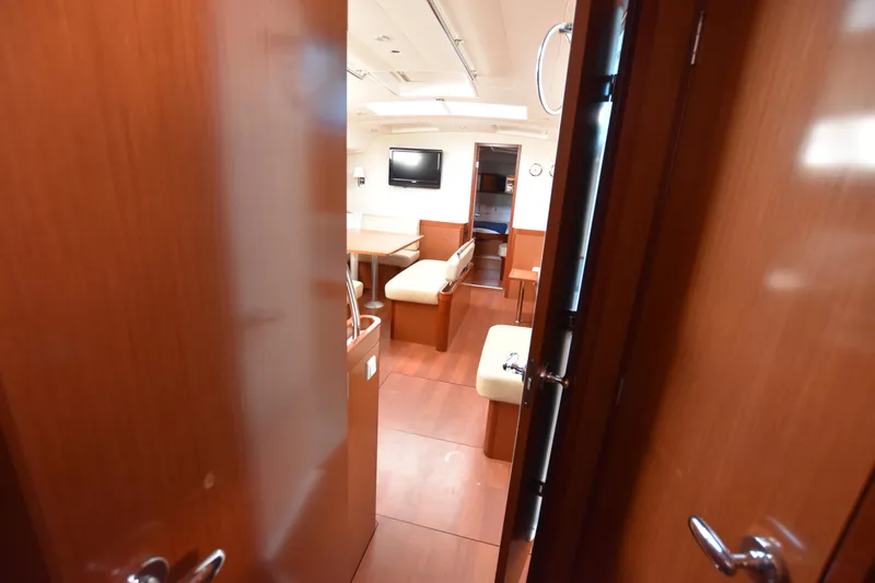 Panope Yacht Photos Pics Interior view of 2009 Beneteau Oceanis 54 yacht, featuring wooden finishes and cozy seating.