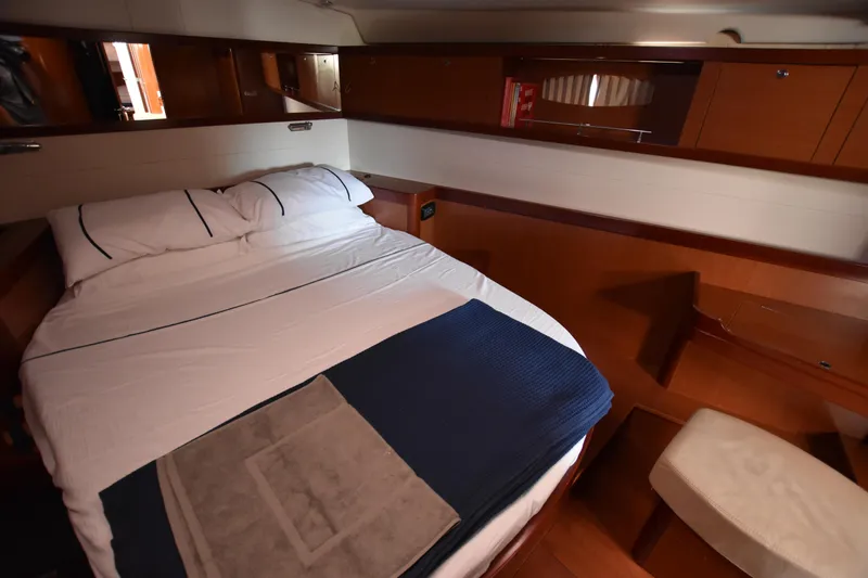 Panope Yacht Photos Pics Luxurious cabin interior of 2009 Beneteau Oceanis 54 yacht with cozy bed and wooden furnishings.