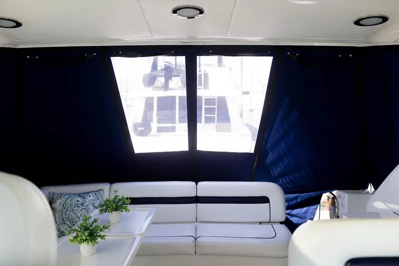 Kylie Marie Yacht Photos Pics Interior of 2009 Searay 43 Sundancer yacht with white seating and blue curtains.