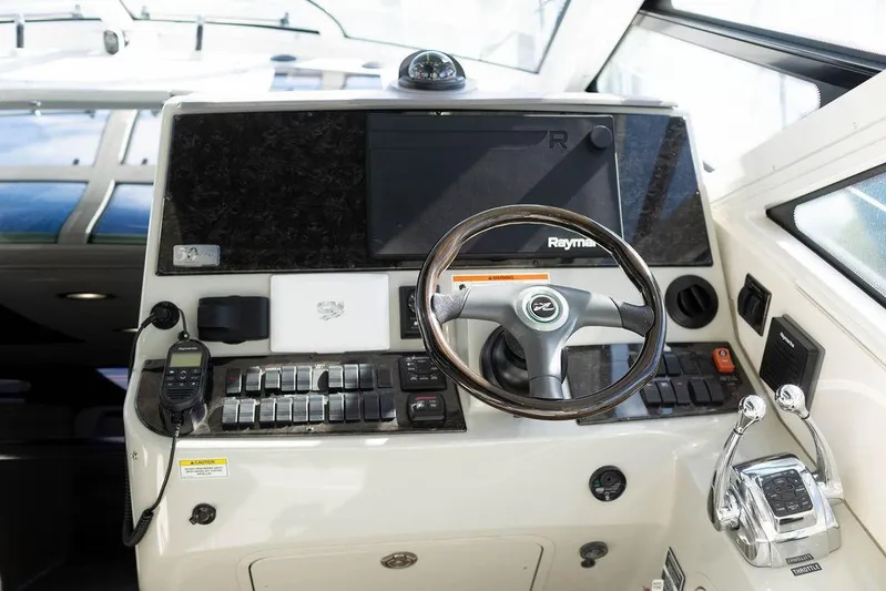 Kylie Marie Yacht Photos Pics Control panel of 2009 Searay 43 Sundancer yacht with steering wheel and navigation equipment.