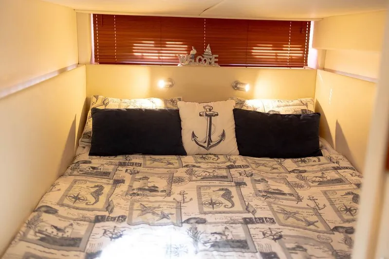 Kylie Marie Yacht Photos Pics Cozy cabin interior of 2009 Searay 43 Sundancer with nautical-themed bedding.