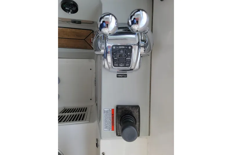 Kylie Marie Yacht Photos Pics Throttle controls of a 2009 Searay 43 Sundancer boat, featuring dual levers and control panel.