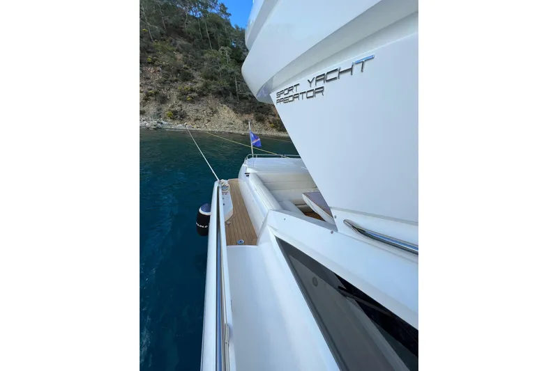 Escape Yacht Photos Pics 2014 Sunseeker 68 Sport Yacht docked by a scenic shoreline.