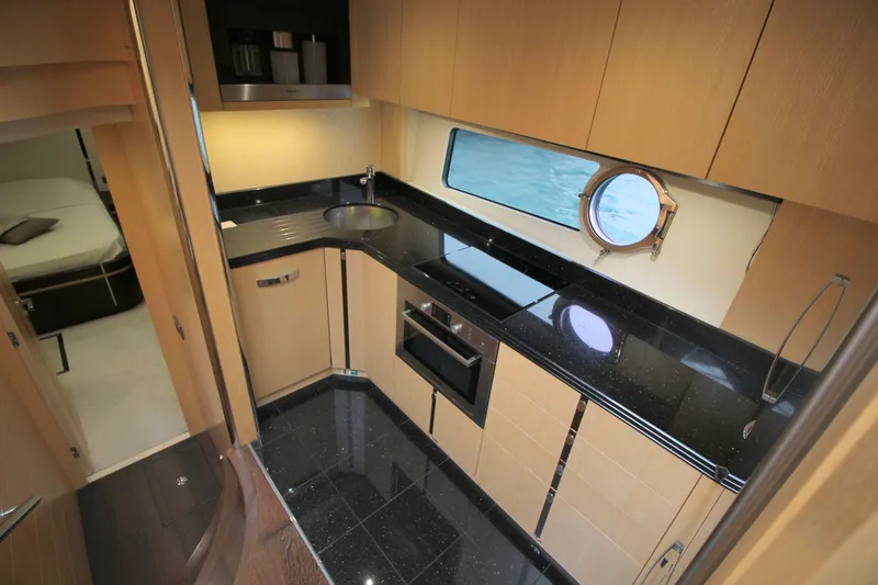Escape Yacht Photos Pics Luxurious kitchen interior of 2014 Sunseeker 68 Sport Yacht with sleek black countertops.