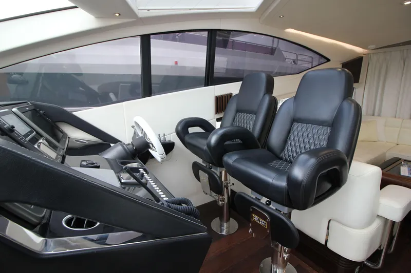 Escape Yacht Photos Pics Luxurious helm seats in 2014 Sunseeker 68 Sport Yacht cockpit, featuring modern controls.
