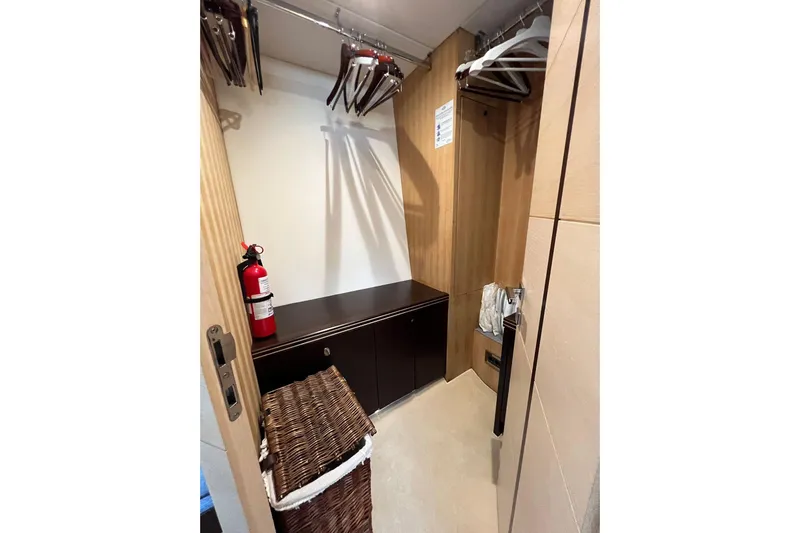 Escape Yacht Photos Pics Closet interior on 2014 Sunseeker 68 Sport Yacht with hangers and fire extinguisher.