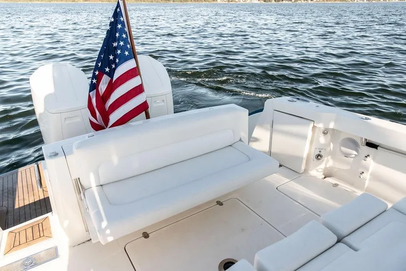 Stargazer Yacht Photos Pics 2024 Hinckley Sport Boat 40c with American flag, white seating, and dual engines on water.