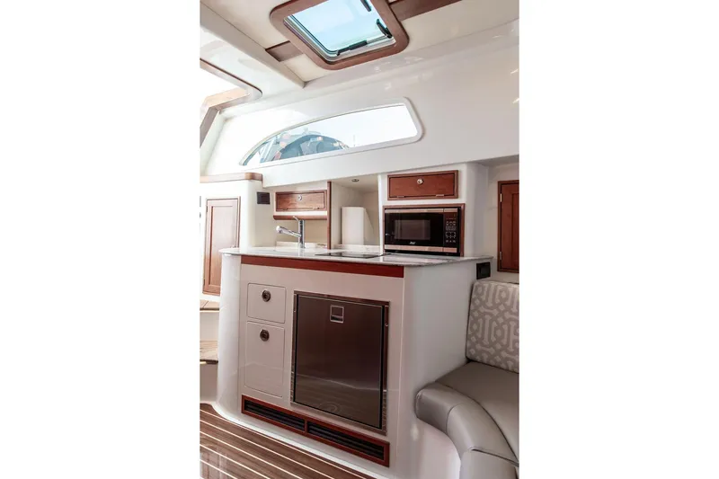Stargazer Yacht Photos Pics 2024 Hinckley Sport Boat 40c interior with kitchenette, featuring wood accents and modern appliances.