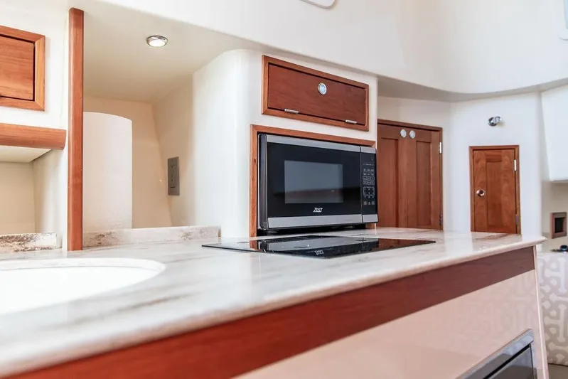 Stargazer Yacht Photos Pics 2024 Hinckley Sport Boat 40c interior with modern kitchen appliances and wooden cabinetry.