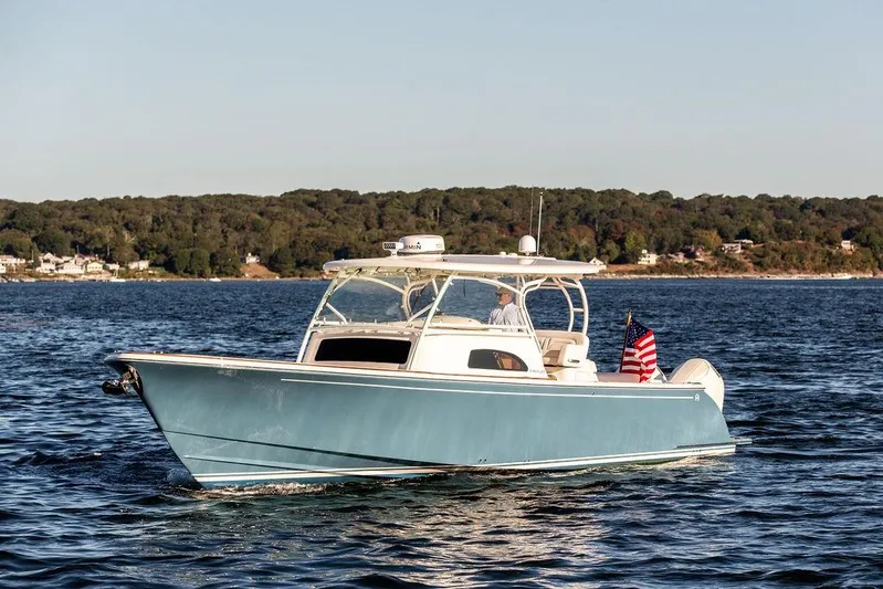 Stargazer Yacht Photos Pics 2024 Hinckley Sport Boat 40c cruising on a serene lake with forested shoreline.