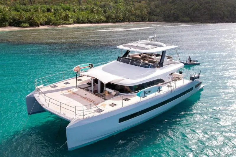 4ever VI Yacht Photos Pics 2022 Lagoon 67 yacht anchored in clear turquoise waters near a tropical island.